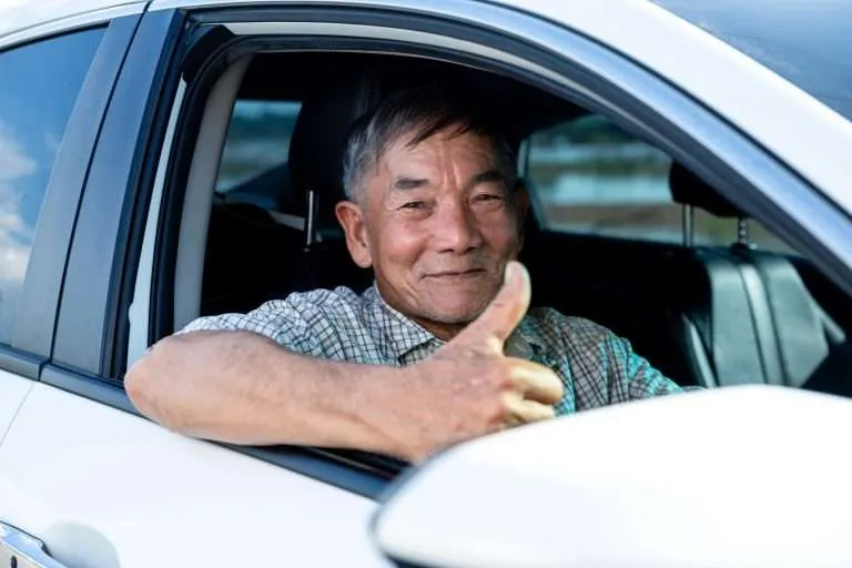 Asian senior man driving car.